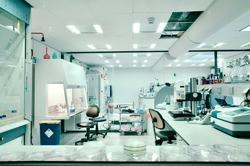 Flask in scientist hand with laboratory background, science research and development concept.