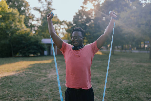 istock An African man is stretching his body with a resistance band and preparing for training in nature. 1483045211