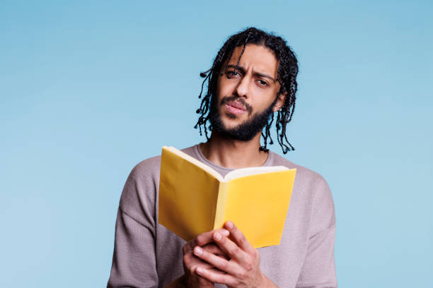 istock Confused arab man reading book and looking at camera 1483045735