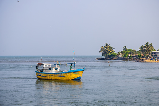 Negombo, Sri Lanka - March 7th 2023: Fishing boat close to the coast outside the fish market in Negombo which is the largest in Sri Lanka and is a center for supplying fish to the capital Colombo and for export
