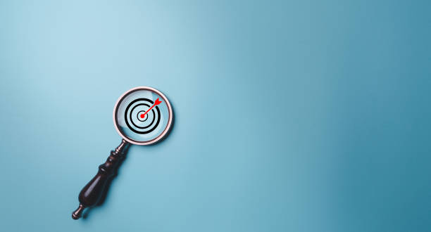 istock Target board inside vintage magnifying glass for focus business objective on blue background and copy space. Search, goal, strategy, success. successful marketing strategy goals 1483046764