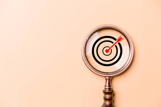 istock Target board inside vintage magnifying glass for focus business objective on orange background and copy space. Search, goal, strategy, success. successful marketing strategy goals 1483046780
