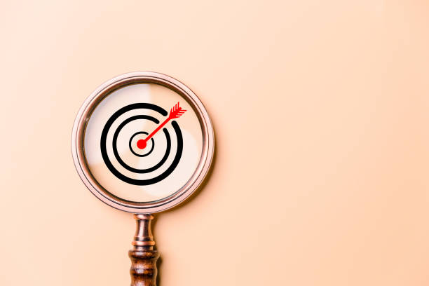 istock Target board inside vintage magnifying glass for focus business objective on orange background and copy space. Search, goal, strategy, success. successful marketing strategy goals 1483046840