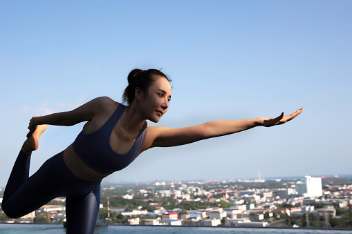 Yoga exercise on roof top of condominium, Healthy and sport lifestyle of Urban people,  Yoga and Fitness Training Class