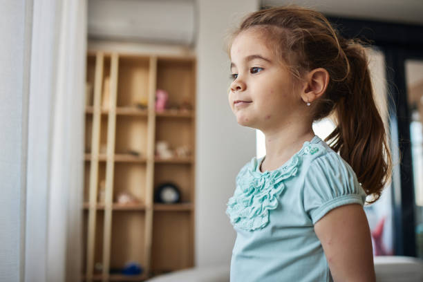 Close-up portrait of smiling little girl looking up. Happy teenage girl looking up with positive facial expression. Horizontal composition. Little girl has got medium length brown hair. Her ethnicity belongs to Turkish ethnicity. Focus on girl.