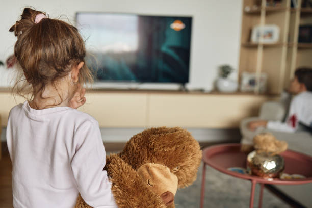 Girl watching TV on sofa at home