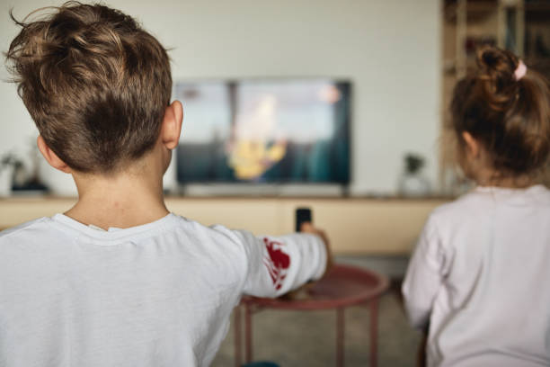istock Boy and girl watching TV on sofa at home 1483048387