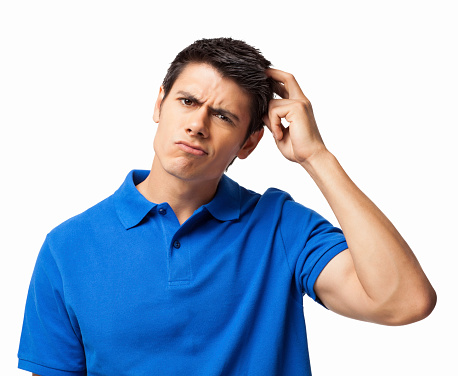 Portrait of confused young man in a casual blue t-shirt scratching his head. Horizontal shot. Isolated on white.