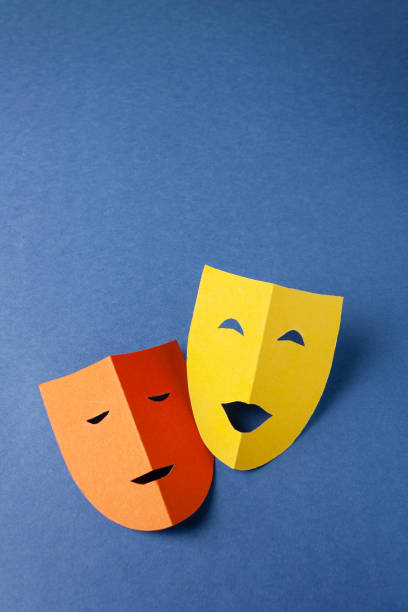 dos máscaras teatrales hechas de papel de color sobre un fondo azul, espacio de copia, foto minimalista - teatro de pantomima británico fotografías e imágenes de stock