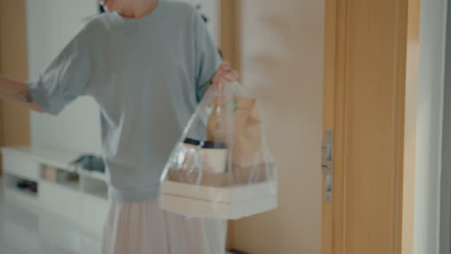 Woman Receiving Bag with Food from Delivery Guy