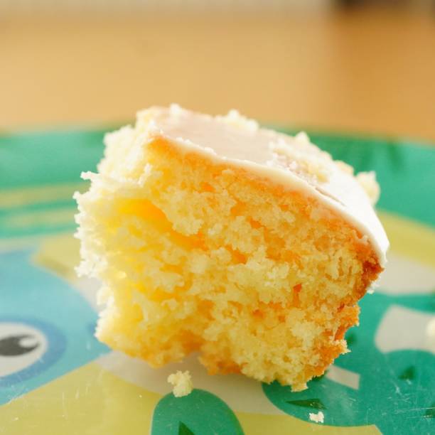 Decadent piece of cake is displayed on a plate, with a layer of dark icing