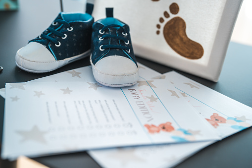 A baby shower activity with baby shoes and illustration on a paper with lines for filling in.