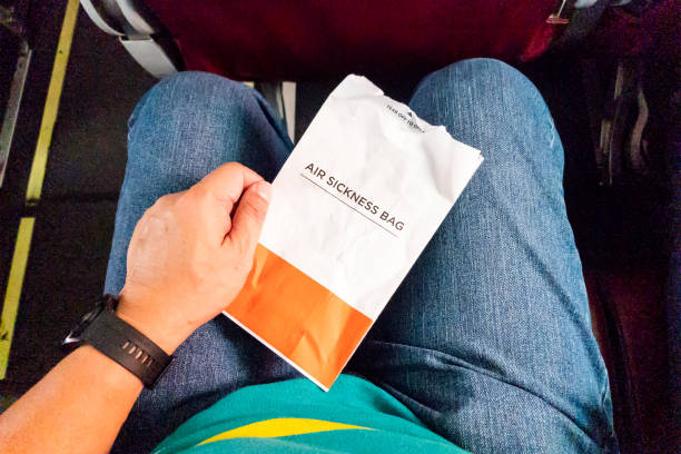 istock Passanger holding air sickness bag during air flight incase need to vomit 1483051849