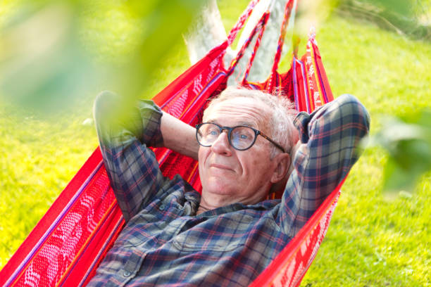 istock Senior man day dreaming while lying on hammock in garden 1483051945