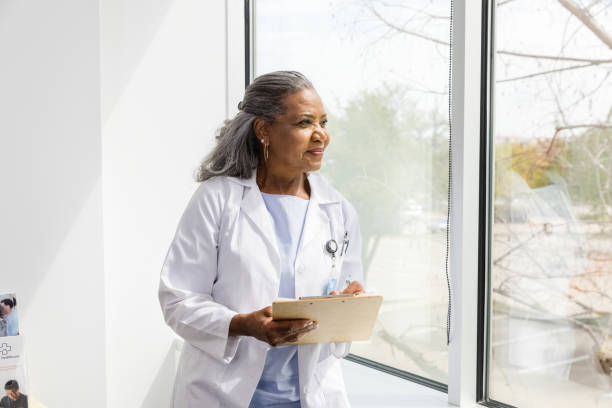 istock Female doctor pauses while making notes to look out the window 1483051948
