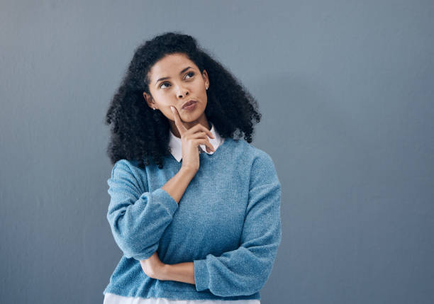 istock Thinking, ponder and woman in a studio contemplating a question or plan in her head. Wondering, pensive and female model from Mexico brainstorming while isolated by gray background with mockup space. 1483052163