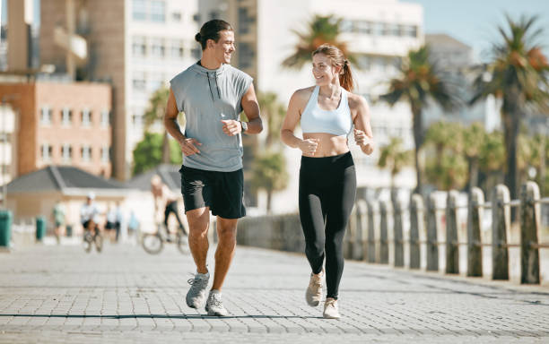 istock Couple, running and training together in the city for exercise, workout or cardio routine in Cape Town. Happy man and woman runner in fitness, walk or jog for healthy wellness or exercising outside 1483052184