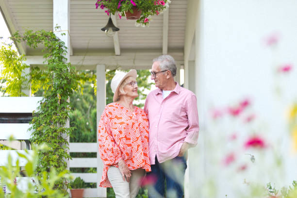 istock Smiling senior couple looking at each other while standing outside house 1483055000