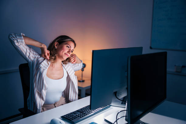 istock Woman stretching out at her desk while working late 1483055829