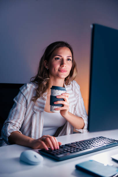 istock Woman drinking coffee while working late in an office 1483056497