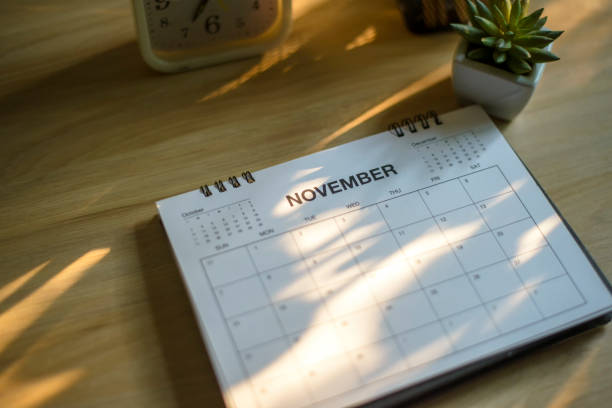 istock Desktop calendar, clock, and cactus placed on student wooden desk. calender for planner to plan daily appointments each day, month, and year on wooden table. Calendar background concept. 1483057165