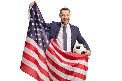 Man holding a USA flag and a soccer ball isolated on white background