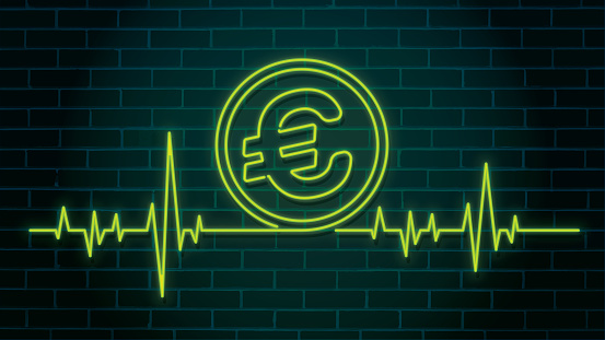 Heartbeat pulse shaped green illuminated neon Euro sign on a brick wall