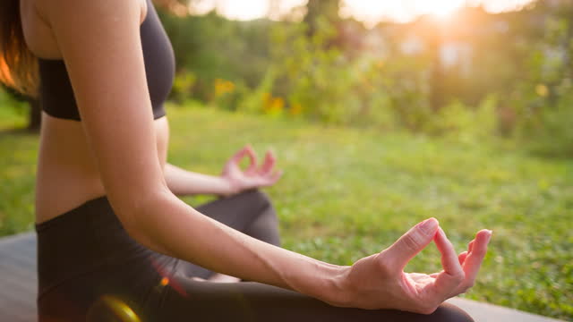 Body conscious woman staying healthy and fit, practicing meditation outdoor in the back yard