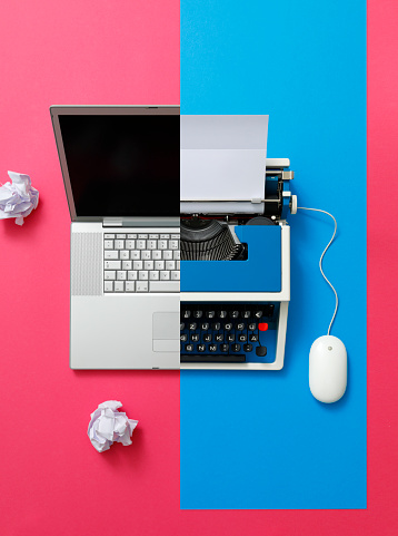 Two generations meeting - modern laptop and 80s typewriter with a computer mouse