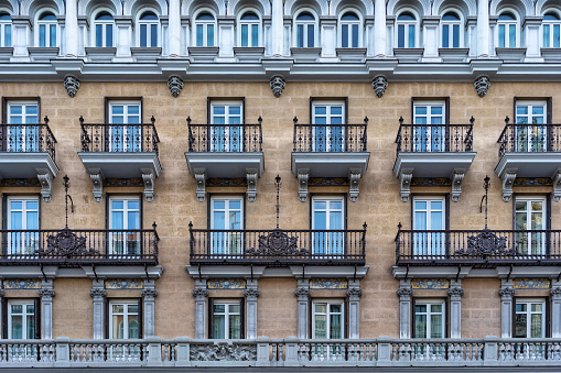 This photo showcases a stunning building facade in the heart of Madrid. The building's sleek lines and design highlight the city's historic architecture, capturing the vibrant energy of Madrid's urban landscape. With an emphasis on bold shapes and dramatic angles, this photo is perfect for illustrating themes of innovation, progress, and creativity.