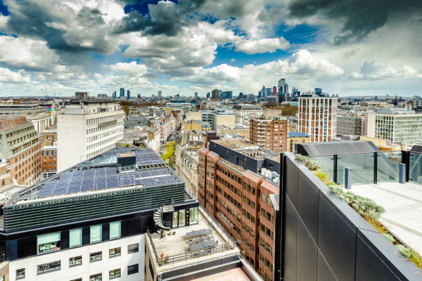 High angle view depicting the futuristic, modern towers and skyscrapers that constitute the economic and financial heart of the city of London. These buildings are interspersed with historic, ancient architecture of yesteryear. Numerous cranes fill the scene, as they construct the next wave of architecture in the heart of the city.