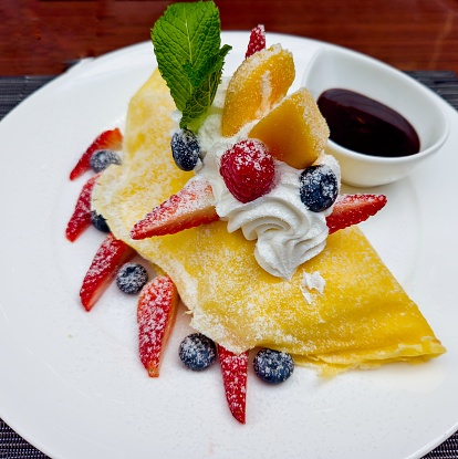 Pancake filled with fresh fruit and whipped cram. Decorated with mint leaf.