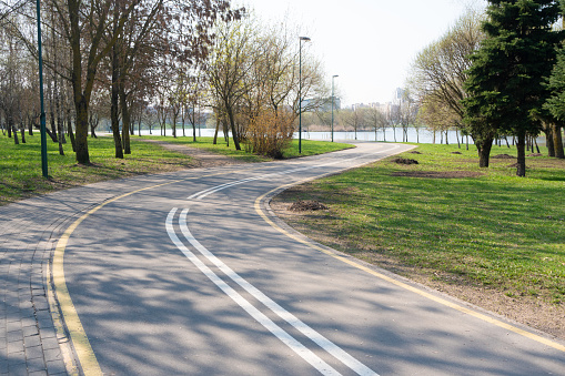 a winding bike path combined with a footpath passing through the city along the river. healthy lifestyle, walks, fresh air, springtime and buds on the trees