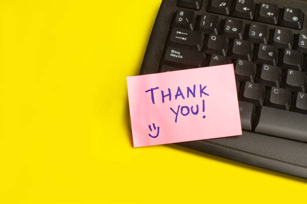 istock A black computer keyboard and a pink paper note with thank you phrase on a yellow background with copy space 1483064990