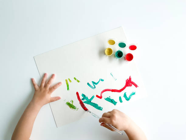 istock small child draws with paints and brush on white table. fathers day 1483065793