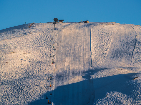 Ski slope during sunset on mountain slope in Alpe D'Huez ski resort - France