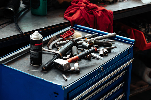 Different tools on workbench in car service close up
