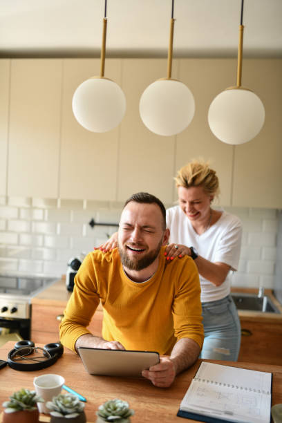 istock Bearded Male Making Faces While Getting Massage From Female At Home And Working On Tablet 1483070883