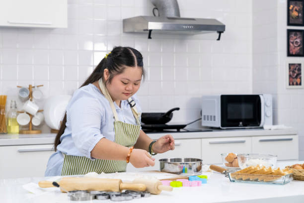 istock Asian person with Down syndrome cooking at kitchen 1483075921