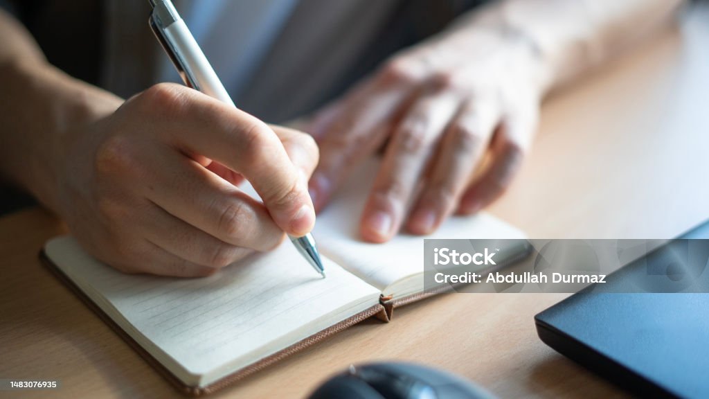 Close-up Man hand writes in notebook Diary Stock Photo