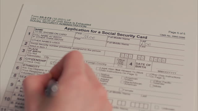 Caucasian Female Hand Filling out Application For A Social Security Card