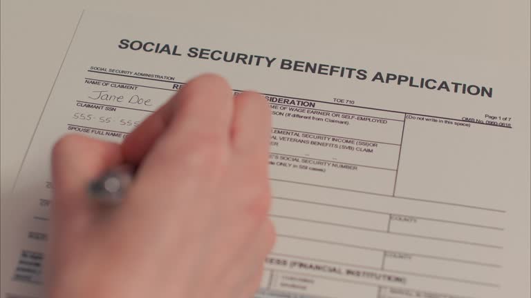 Caucasian Female Hand Filling out Social Security Benefits Application