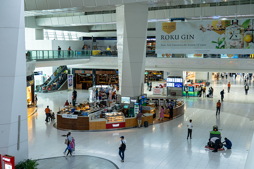 Delhi, India - April 12, 2023: Shops and people inside the departure terminal at Indira Gandhi International Airport.