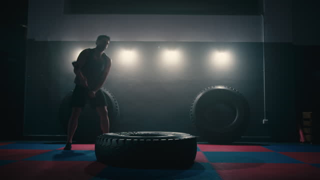 Fitness Man Hitting Wheel Tire With Hammer