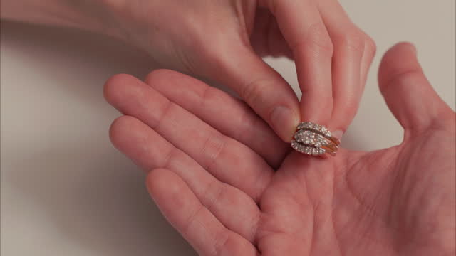 Latino Male Hand Gives Caucasian Woman Hand a Diamond Wedding Ring