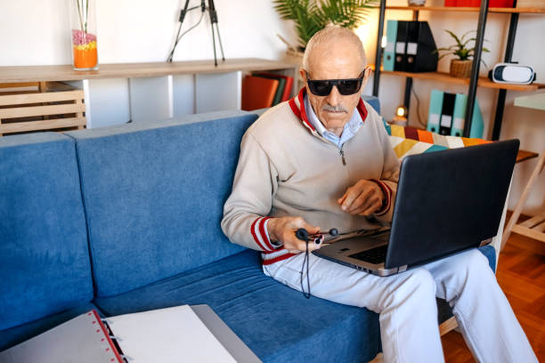 istock Active blind senior adult sitting on sofa in living room 1483084359