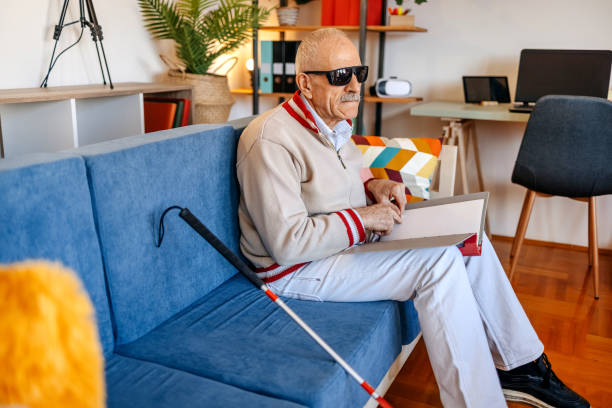 istock Blind old man having a call on mobile phone in living room 1483084361