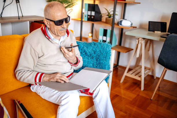 Blind old man having a call on mobile phone in living room