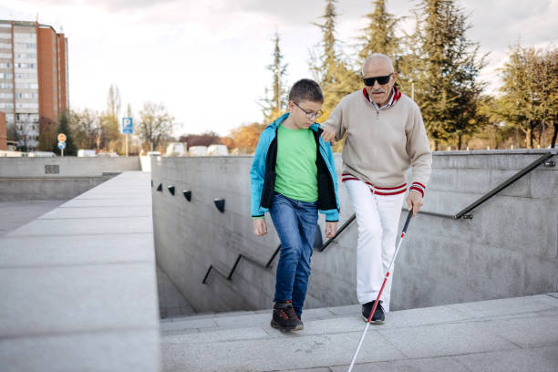 istock Child supporting blind old person with climbing stairs and walk 1483084638
