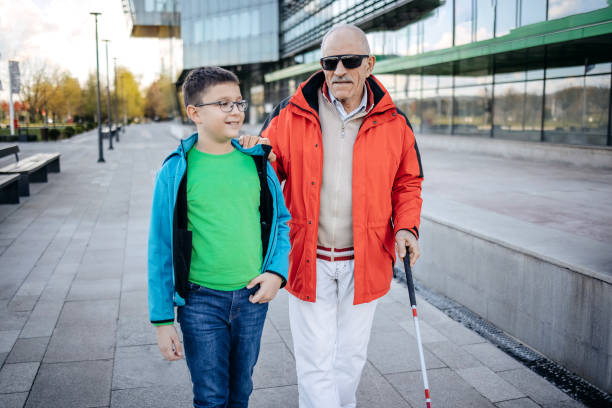 Child supporting blind old person with climbing stairs and walk